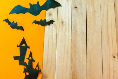 Cadılar Bayramı konsepti Turuncu ve ahşap arka planda yarasaları olan cadının evi. Metin ve tasarım için boş boşluk.