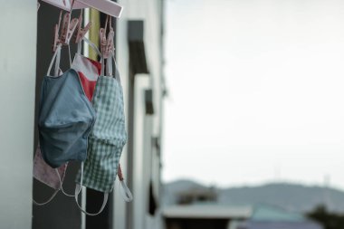 Odanın penceresinin üzerinde kumaştan yapılmış el yapımı maskeler asılı. Yıkanabilir ve yeniden kullanılabilir. Koroner virüs salgını nedeniyle cerrahi maske kıtlığında kullanılabilir. Covid-19 virüsü. Boşluğu kopyala
