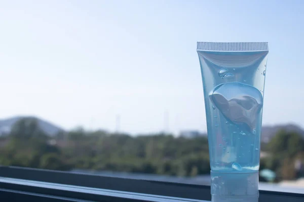 The alcohol gel bottle is on the right side. On the window sill and the background is the sky. Alcohol gel for hand washing Anti-virus and anti-bacterial and anti-virus Covid-19. copy space.
