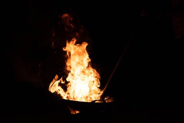 Kavrulmuş kaju tavasındaki ateşten çıkan kırmızı turuncu alev.