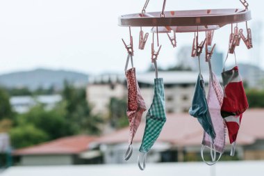 Odanın penceresinin üzerinde kumaştan yapılmış el yapımı maskeler asılı. Yıkanabilir ve yeniden kullanılabilir. Koroner virüs salgını nedeniyle cerrahi maske kıtlığında kullanılabilir. Covid-19. Boşluğu kopyala