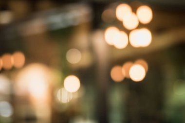 Kafe arka planında tasarımda ışık efektiyle iç mekanın soyut bulanıklığı. Bokeh 'le kafenin arka planı bulanık. turuncu, kırmızı, ışık.