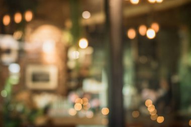 Kafe arka planında tasarımda ışık efektiyle iç mekanın soyut bulanıklığı. Bokeh 'le kafenin arka planı bulanık. turuncu, kırmızı, ışık.