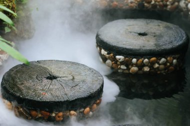 Hot Springs, gayzer menfezinde kaynayan ve kaynayan su. Buharlı jeotermal sıcak su, büyük taşlar sıralanmış, kaynar su sıçraması. Yakın plan, eski tarz. Boşluğu kopyala.