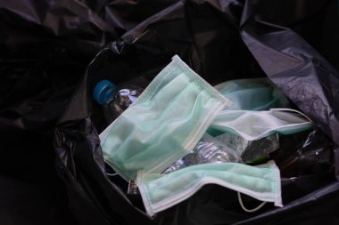 Kullanılmış bir maskeyi hijyenik olmayan bir ortamda bırakarak çöpe atmak zararlı mikroplar ve virüsler yayılabilir. Sağlık hizmetleri kavramları. yeşil maske.