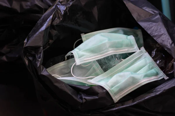 Disposing of a used mask in the trash By leaving unhygienic There may be a spread of harmful germs and viruses. Healthcare concepts. green mask.