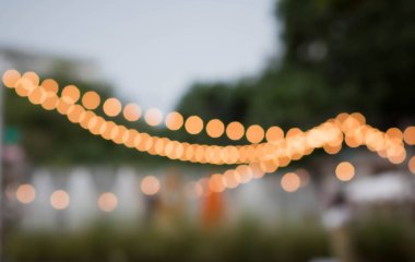 Siracha, Tayland 'daki sahil restoranının ışıklarını bulanıklaştır. Bokeh 'le kafenin arka planı bulanık. Parlak deniz manzarası. Kahve dükkanının soyut bulanıklığı. Turuncu, kırmızı, açık.