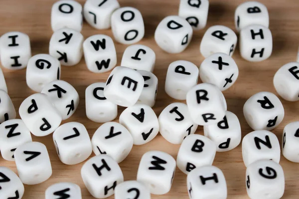 木制背景的文本骰子立方体概念 字母脚本字母表 地板上钉的字母表块 图库照片