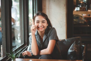 Vintage arka planda izole edilmiş mutlu genç bir bayan görüntüsü. Kamera işaret ediyor, kırmızı, ışık. Bağbozumu etkisi. Boşluğu kopyala.