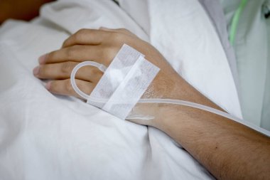 Hastane koğuşundaki bir hastanın eline odaklan. Hasta hastane yatağında..