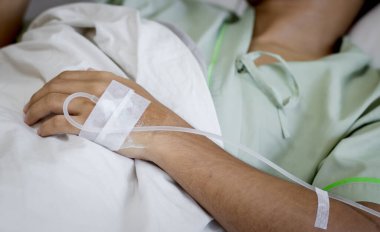 Hastane koğuşundaki bir hastanın eline odaklan. Hasta hastane yatağında..