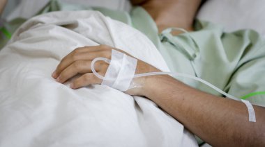 Hastane koğuşundaki bir hastanın eline odaklan. Hasta hastane yatağında..