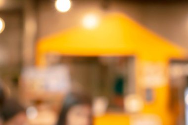 Kafe arka planında tasarımda ışık efektiyle iç mekanın soyut bulanıklığı. Bokeh 'le kafenin arka planı bulanık. turuncu, kırmızı, ışık.