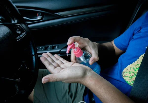 Close up hand holding alcohol gel in car. Hand sanitizer gel for clean and against the corona virus, covid-19, bacteria. Hand cleanser. Health care concept. copy space.