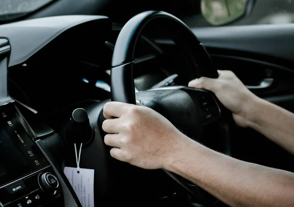 hands of a man with car steering wheel is ready on the move in the modern life style.