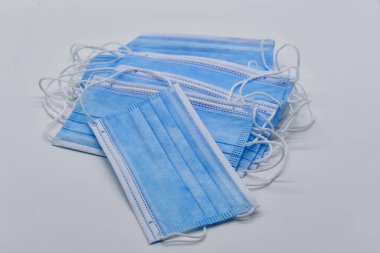 Açık arkaplanda birkaç mavi koruyucu maske.