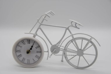 Süs olarak saati olan beyaz bisiklet.