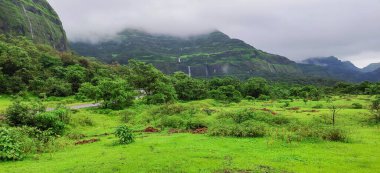 Waterfalls flowing from scenic Western Ghats mountains of Tamhini near Pune Maharashtra during monsoon season. Perfect travel background. Monsoon magic landscape banner. clipart