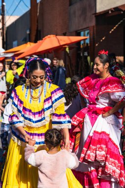 Phoenix, AZ - 30 Kasım 2019: Yerel halk dansları grubu, Açık Hava Çiftçi Pazarı 'nda bir çocukla geleneksel Meksika dansları yapıyor ve dans ediyor..