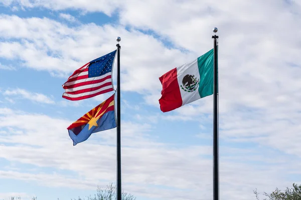 Tucson, AZ - 26 Kasım 2019: Arizona-Sonora Çölü Müzesi üzerinde dalgalanan Meksika, Amerika Birleşik Devletleri ve Arizona eyaletinin bayrakları Sonora Çölü 'nün bir sınır ötesi çöl olduğu gerçeğini yansıtmaktadır..