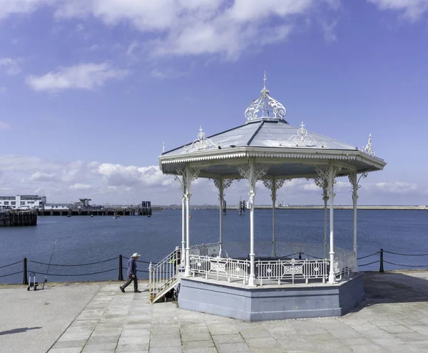 Doğu İskelesi, Dun Laoghaire, Dublin, İrlanda 'daki yenilenmiş orkestra stanesi ve güneş sığınağı. Aslen 1890 'da inşa edilmiş ve işlenmiş ve dökme demirden yapılmış.. 