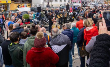 Bir rock 'n roll grubu, Portekiz, Loule' daki Noel kutlamalarının bir parçası olarak meyve pazarının dışındaki kalabalığı eğlendiriyor.. 