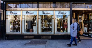 Nassau Caddesi, Dublin, İrlanda 'daki Peterson puro ve tütün dükkanının önünden geçen müşteriler.