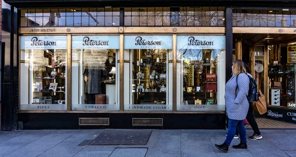 Nassau Caddesi, Dublin, İrlanda 'daki Peterson puro ve tütün dükkanının önünden geçen müşteriler.