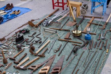 Aylık bit pazarı, Quarteira, Portekiz 'de, ikinci el ürünlerin geniş bir yelpazesi satışta. Bu bölümde ikinci el aletler yere saçılmıştır..