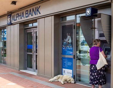 Alpha Bank şubesinde ATM kullanan bir kadın. Halkidiki, Yunanistan, 