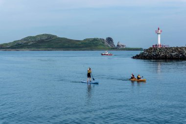 Arka planda Irelands Göz Adası ile Howth, Harbour, Dublin, İrlanda 'da kayak ve kano sporu.