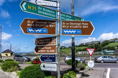 Bantry, County Cork, İrlanda 'da Vahşi Atlantik Yolu, Skibbereen, Whiddy Adası ve diğer yerlere giden yol güzergahı yazan bir tabela..