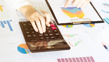 İş kadınları mali giderleri hesaplamak ve analiz etmek için hesap makineleri kullanırlar. Bir hesap makinesi aracılığıyla mali ve ekonomik tasarruf kavramları. İş konsepti