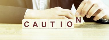 Adam ahşap bloklarla kelime CAUTION yaptı