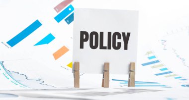 Dosya, zar, gözlük, kalem, dizüstü bilgisayar ve mavi ve sarı broşlu kağıt üzerinde politika metni - işletme, bankacılık, finans ve yatırım konsepti
