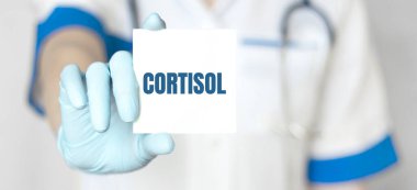 Doktor elinde CORTISOL yazılı bir kart tutuyor, tıbbi konsept.
