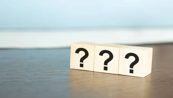 ? Questions Mark word in wooden cube block on table background. FAQ Answer, Q&A.
