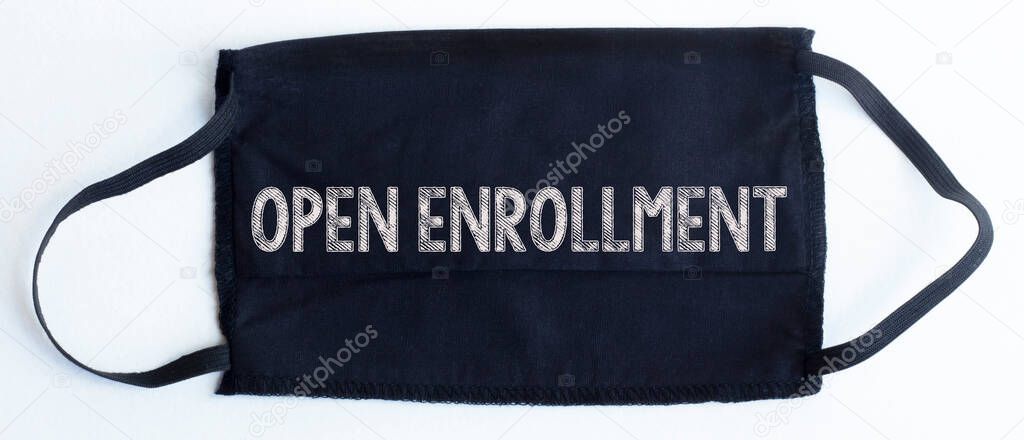 Black disposable protective mask with open enrollment text on black background.