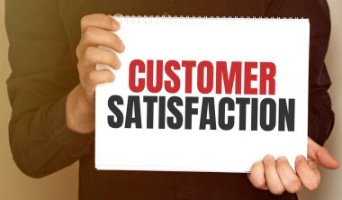 Müşteri Memnuniyeti yazılı bir kart tutan iş adamı