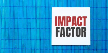 BLUE ahşap arkaplan üzerinde IMPACT FACTOR metin ile boş not defteri