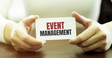 İş kadını elinde metin içeren bir kart tutuyor. Olay Yönetimi ellerinde.