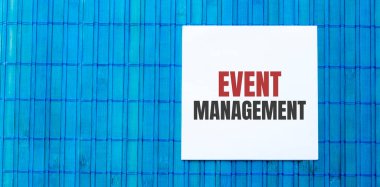 Mavi ahşap arkaplan üzerine etkinlik yönetim metni içeren boş not defteri