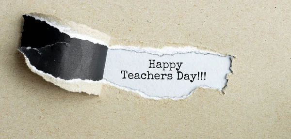 The text Happy Teachers Day appearing behind torn brown paper