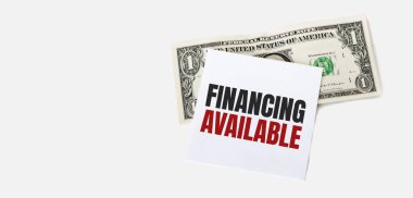 Beyaz arka planda 1 dolarlık banknot ve beyaz not kağıdı.