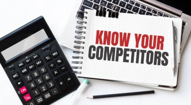 Bilgisayarın klavyesi, hesap makinesi, kalem ve not defteri beyaz arkaplandaki COMPETITOR 'larınızı tanıyın