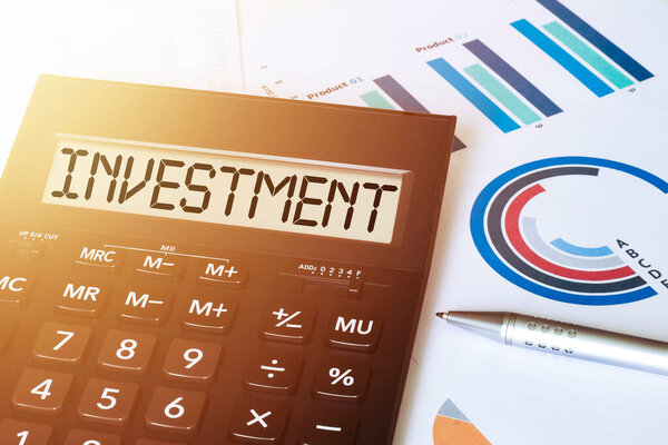 Word INVESTMENT on calculator. Business and finance concept.