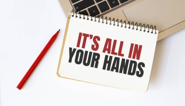 Dizüstü bilgisayar, kırmızı kalem ve beyaz arka planda hepsi senin elinde yazılı not defteri.