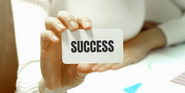 Businesswoman holding a card with text SUCCESS