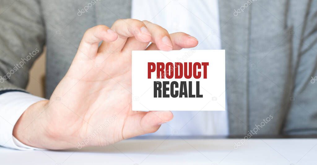 Businessman holding a business card with text Product Recall