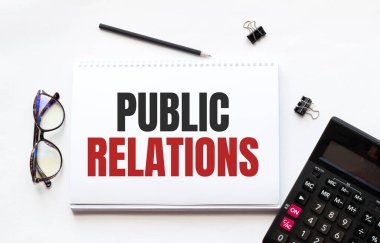 İş konsepti. Not defteri beyaz arka planda notlar, hesap makinesi, gözlük, kalem, kalem ve kalem için PUBLIC ilişkili beyaz kağıt sayfa